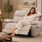 A woman sit on a light gray upholstered recliner sofa