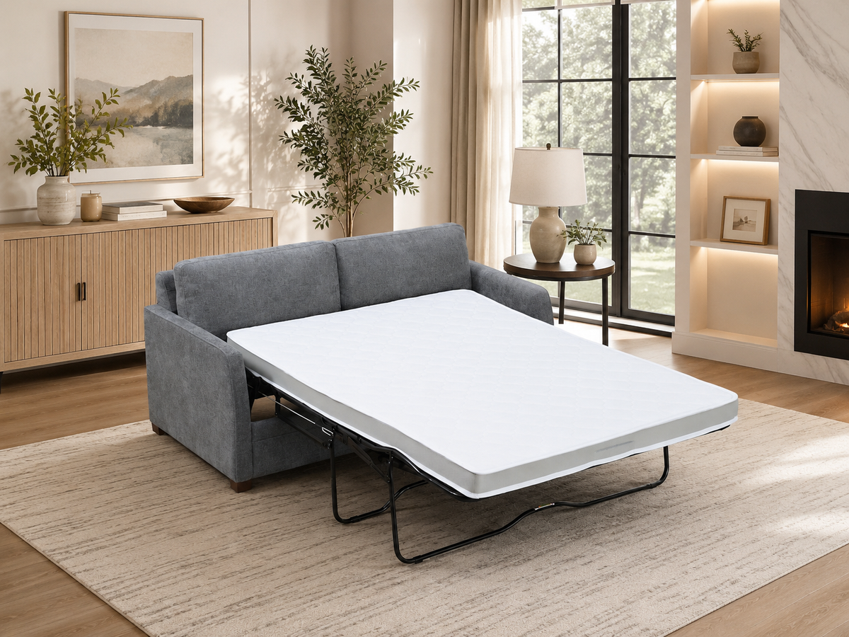 A gray upholstered sleeper sofa with white mattress