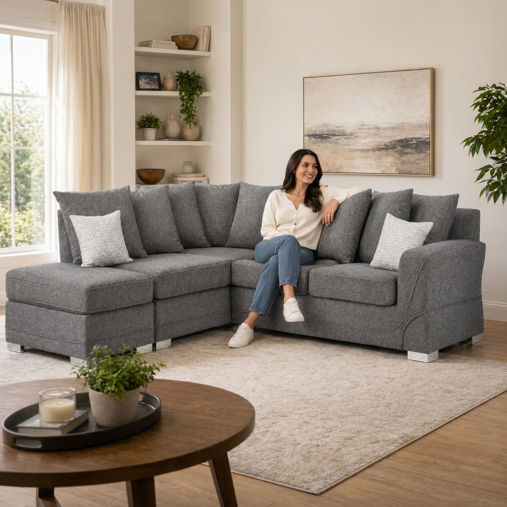 woman sits on a large gray sectional sofa