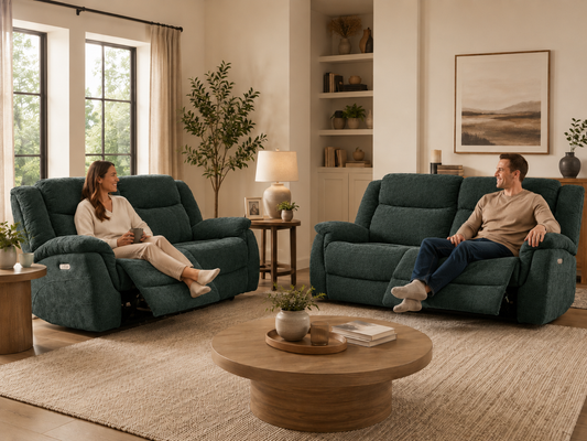 Man and a woman sit on dark teal reclining loveseats